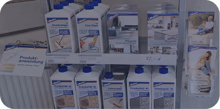 Regal mit Reinigungsprodukten von Livos für Holzpflege und Fleckentfernung, darunter Grundreiniger, Easy Clean und Holzöl, mit Anwendungsbeispielen.