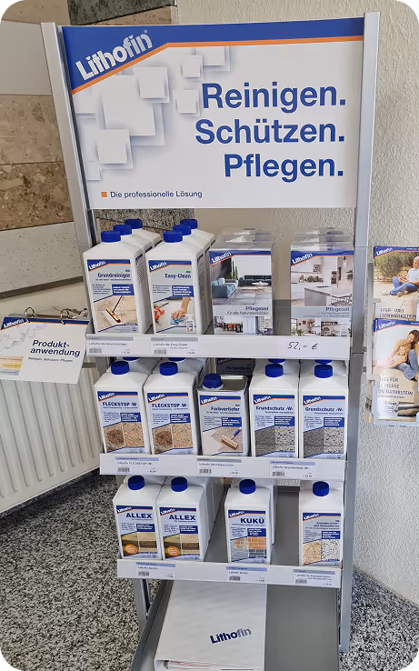 Verkaufsregal mit Lithofin Reinigungs- und Pflegeprodukten für Böden, darunter Grundreiniger, Fleckenentferner und Farbtiefeprodukte.
